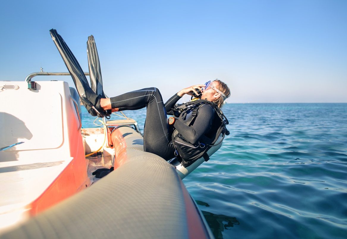 A diver rolling back off the boat into the sea